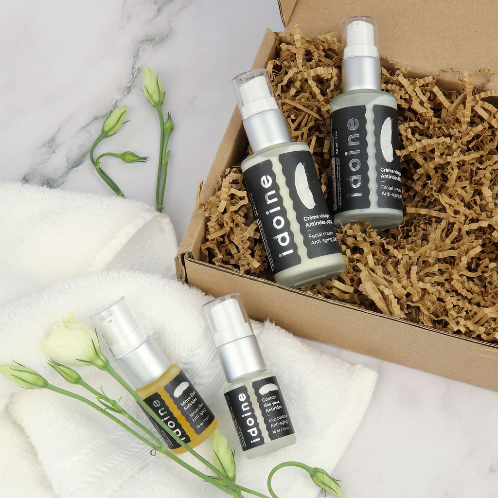 Produits de soins naturels Idoine Bio comprenant une crème visage, une huile faciale et un soin contour des yeux présentés dans un coffret cadeau.