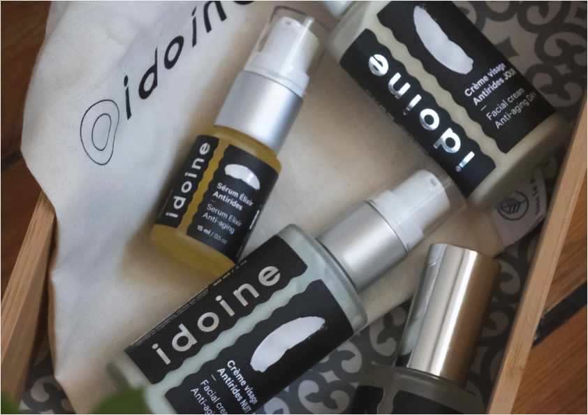 Idoine organic anti-aging skincare set including serum elixir, day cream, night cream, and tonic in frosted glass pump bottles, eco-friendly natural skincare collection