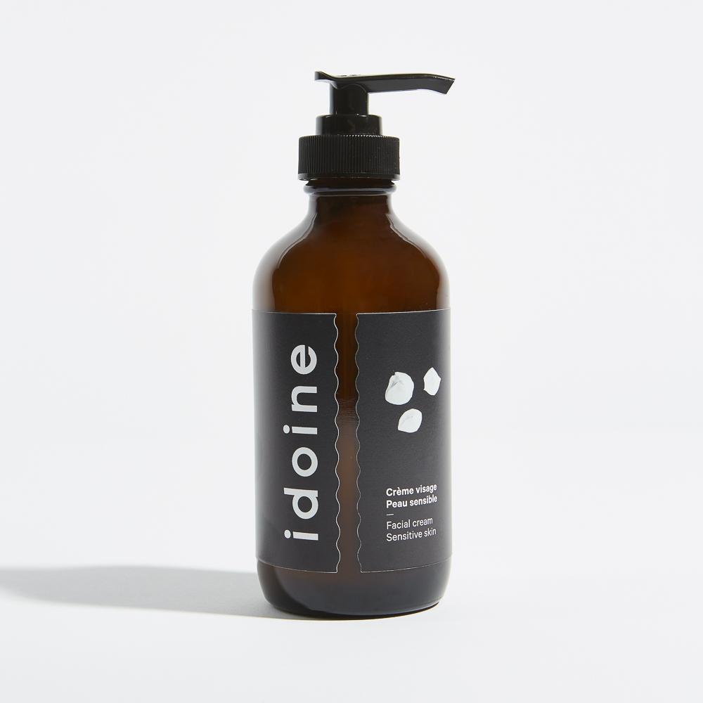 Brown pump bottle of Idoine facial cream for sensitive skin, with a black label and minimalist design, photographed against a white background